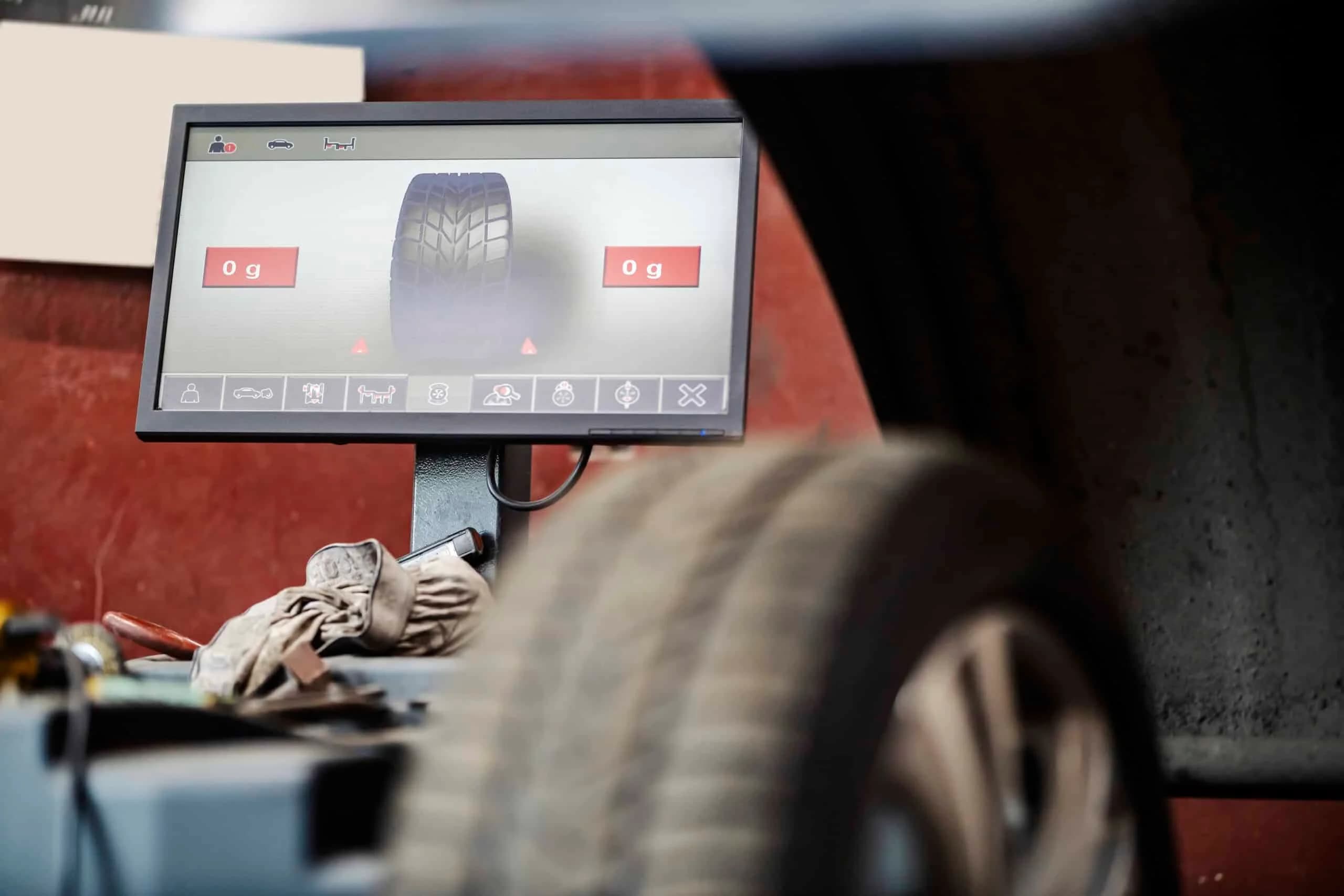 Focus on monitor of car wheel balancing device at vulcanizing workshop.